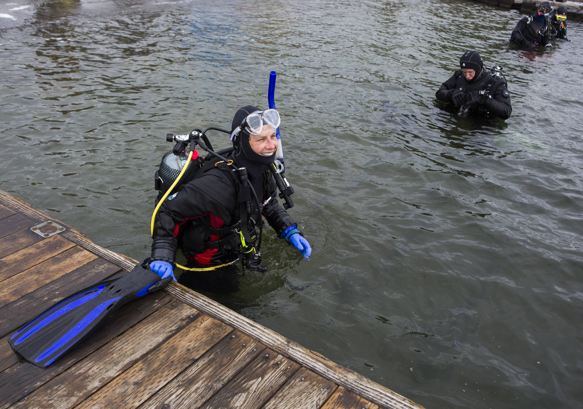 Jenny Righi puts on her flippers May 23 before heading out into the water to search for trash and debris near the shoreline at Davies Beach in Lake Stevens. (Olivia Vanni / The Herald)