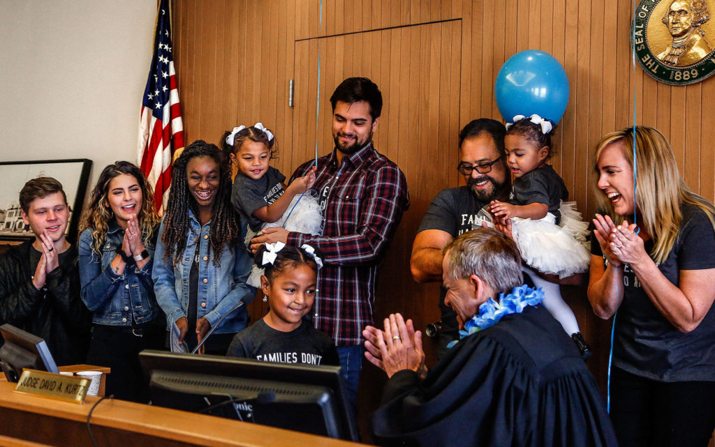 Arlington’s Avellaneda family joins Judge David Kurtz at his bench as Mayah, 6, strikes his gavel Nov. 22, 2019, National Adoption Day. (Dan Bates / Herald file)
