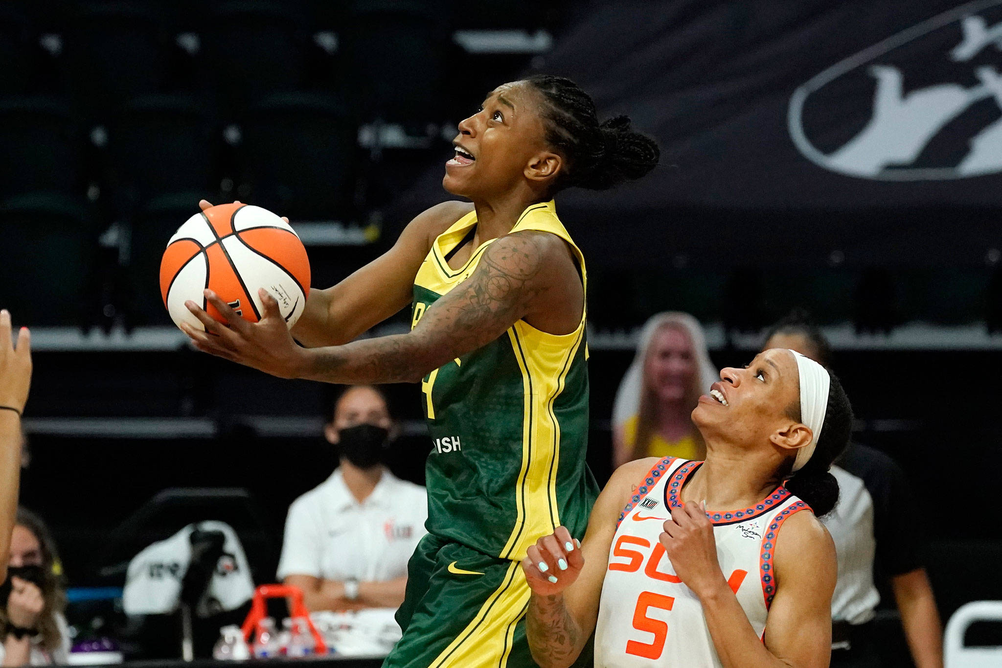 The Storm’s Jewell Loyd (left) drives for a layup past the Sun’s Jasmine Thomas during overtime of a game on May 25, 2021, at Angel of the Winds Arena in Everett. The Storm won 90-87. (AP Photo/Elaine Thompson)