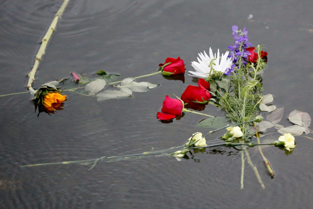 Flowers are placed on the still waters of Lake Stevens on the one-year anniversary of the death of George Floyd. (Kevin Clark / The Herald)
