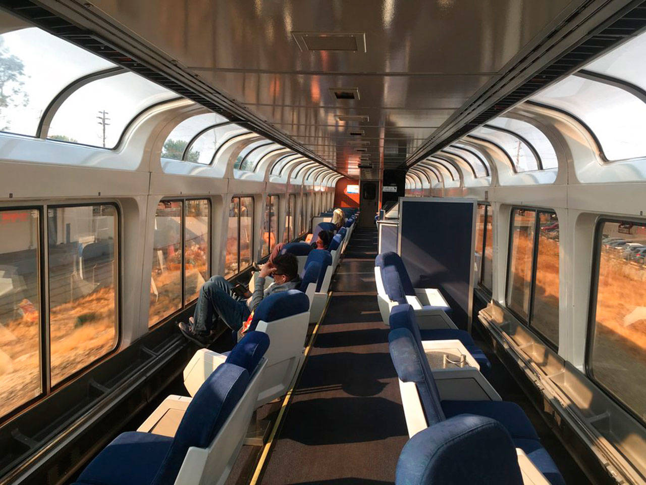 Passengers lounge in the observation car of Amtrak’s Coast Starlight on the way from Los Angeles to Seattle in December 2017. The scenic 35-hour route travels from southern California to Seattle, and has been restored to daily service following last year’s pandemic cutbacks. (Nicole Evatt / Associated Press file photo)