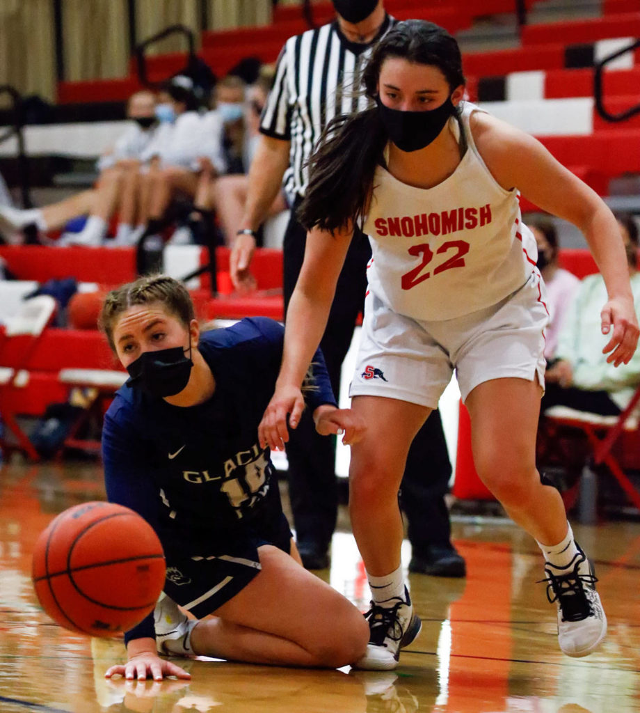 Glacier Peak’s Malia Smith (left) and Snohomish’s Jada Rodgers watch a loose ball during a game on Friday evening at Snohomish High School. Grizzlies won 59-35. (Kevin Clark / The Herald)
