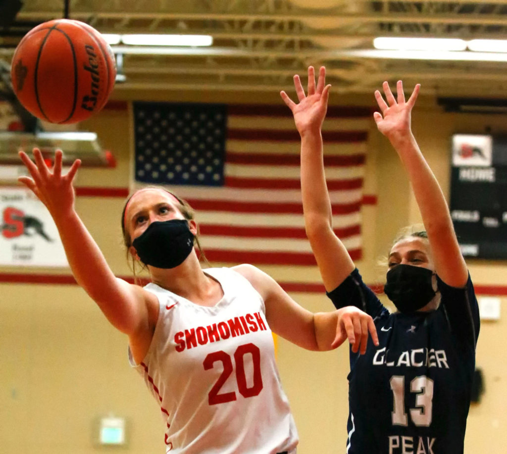 Snohomish’s Sara Rodgers reaches for a rebound with Glacier Peak’s Hailey Stevenson during a game on Friday evening at Snohomish High School. Grizzlies won 59-35. (Kevin Clark / The Herald)
