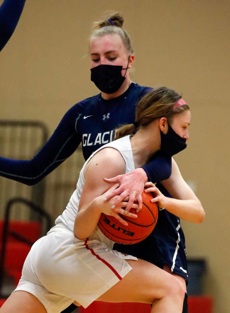 Snohomish’s Cheyenne Rodgers works to get around Glacier Peak’s Madison Rubino during a game on Friday evening at Snohomish High School. Grizzlies won 59-35. (Kevin Clark / The Herald)
