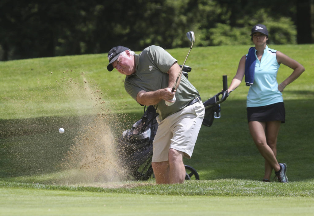 Greg Whisman hits out of a bunker. (Andy Bronson / The Herald)
