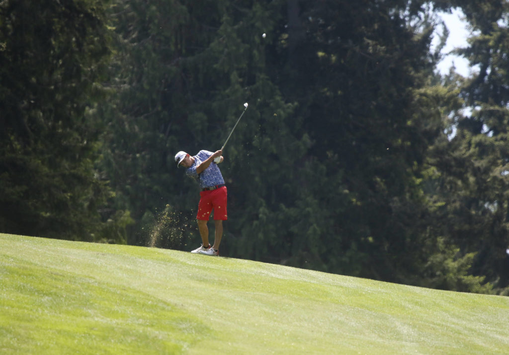 After hitting into another fairway, Mark Strickland hits a shot. (Andy Bronson / The Herald)
