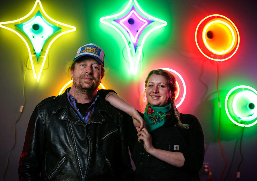 Neon artist Tim Leonard (left), owner of The Machine Shop arcade in Langley, spent much of the pandemic making art pieces and teaching the craft to his daughter Sage Leonard. The neon art is on display at the arcade through June. (Kevin Clark / The Herald)
