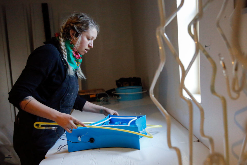 Sage Leonard assembles a neon art piece for an exhibit. She was taught by her dad, Tim Leonard. (Kevin Clark / The Herald)
