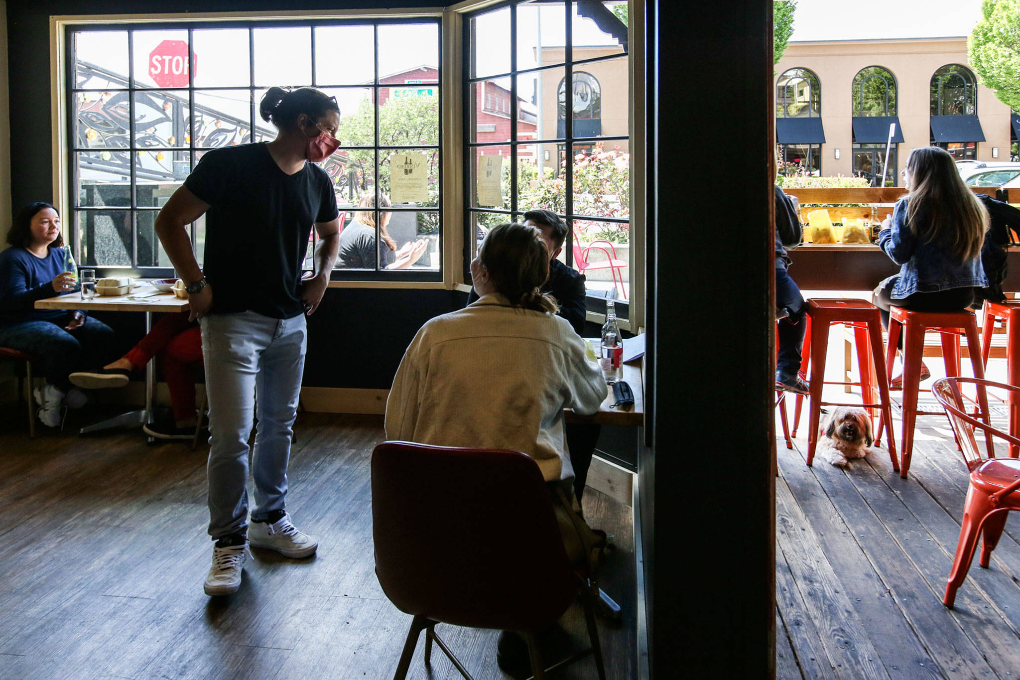 Kris Kelnero talks with customers at Vinbero, a wine bar and restaurant in Edmonds, during the venue’s soft opening last Friday. (Kevin Clark / The Herald)