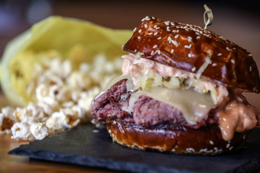 The pretzel reuben at Vinbero, a wine bar and restaurant in Edmonds, is served with a side of salt-and-pepper popcorn. (Kevin Clark / The Herald)

