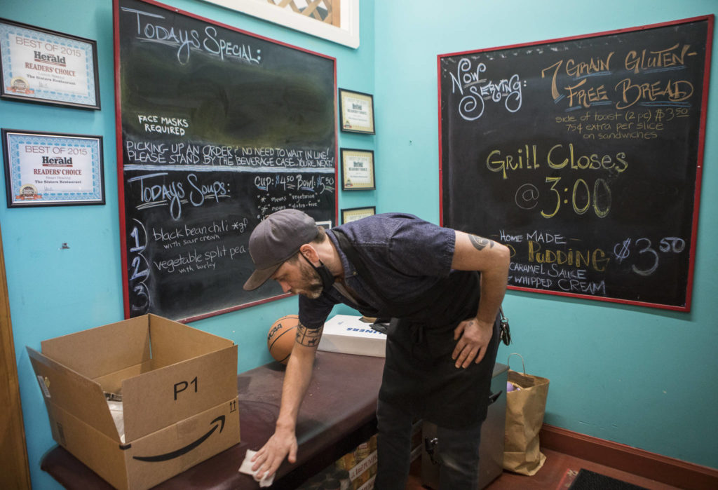 New co-owner Jackson Quall, grandson of former owner Martha Quall, wipes down surfaces in preparation for re-opening the popular Sisters Restaurant in Everett. (Olivia Vanni / The Herald)
