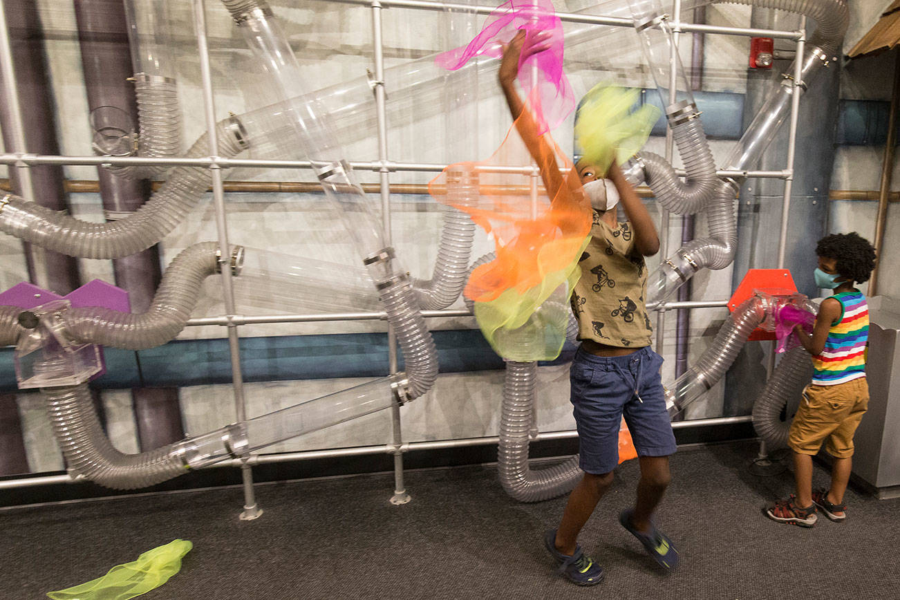 Isaac Nabors, 9, keeps an eye on falling fabric as he and his brother Eli catch rags that float down in the Air Mazing Laboratory at Imagine Children's Museum on Wednesday, June 2, 2021 in Everett, Washington.The museum has reopened,to members only, with reservations only and masks required. (Andy Bronson / The Herald)