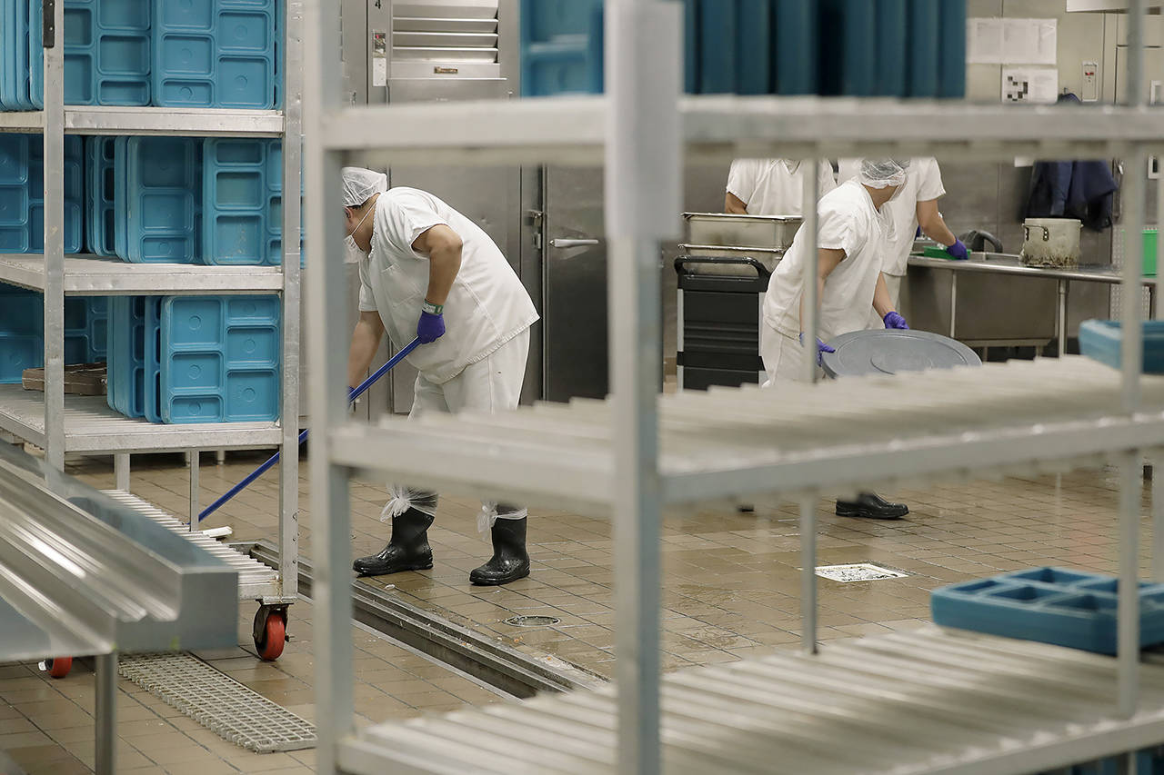 In this 2019 photo, workers are shown in the kitchen of the U.S. Immigration and Customs Enforcement detention facility in Tacoma. (AP Photo/Ted S. Warren, File)