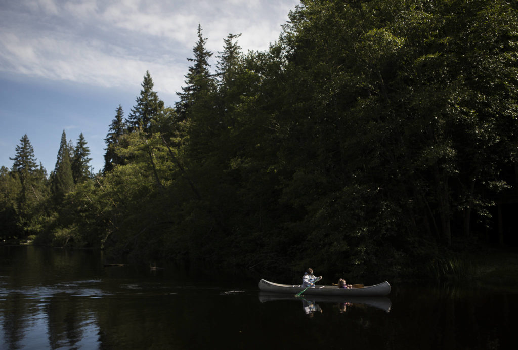 Hannah Davis and Zienna Zink paddle toward shore at Camp Killoqua. (Olivia Vanni / The Herald)
