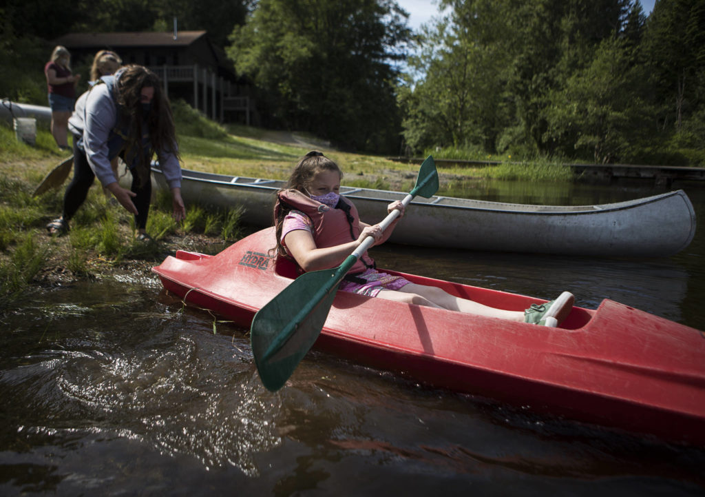 Gemma Rommel, 8, is pushed out into the water aboard a kayak. (Olivia Vanni / The Herald)
