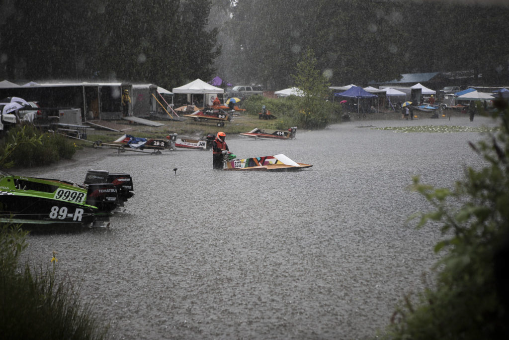 A racer holds onto his boat in the pits as a rainstorm passes through during the Silver Lake Regatta on Saturday, June 5, 2021 in Everett, Wash. (Olivia Vanni / The Herald)
