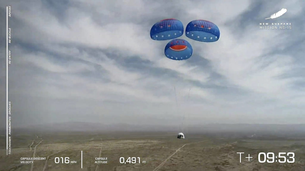 In this image from video, the New Shepard capsule uses parachutes to land during a test in West Texas on April 14. (Blue Origin via AP)
