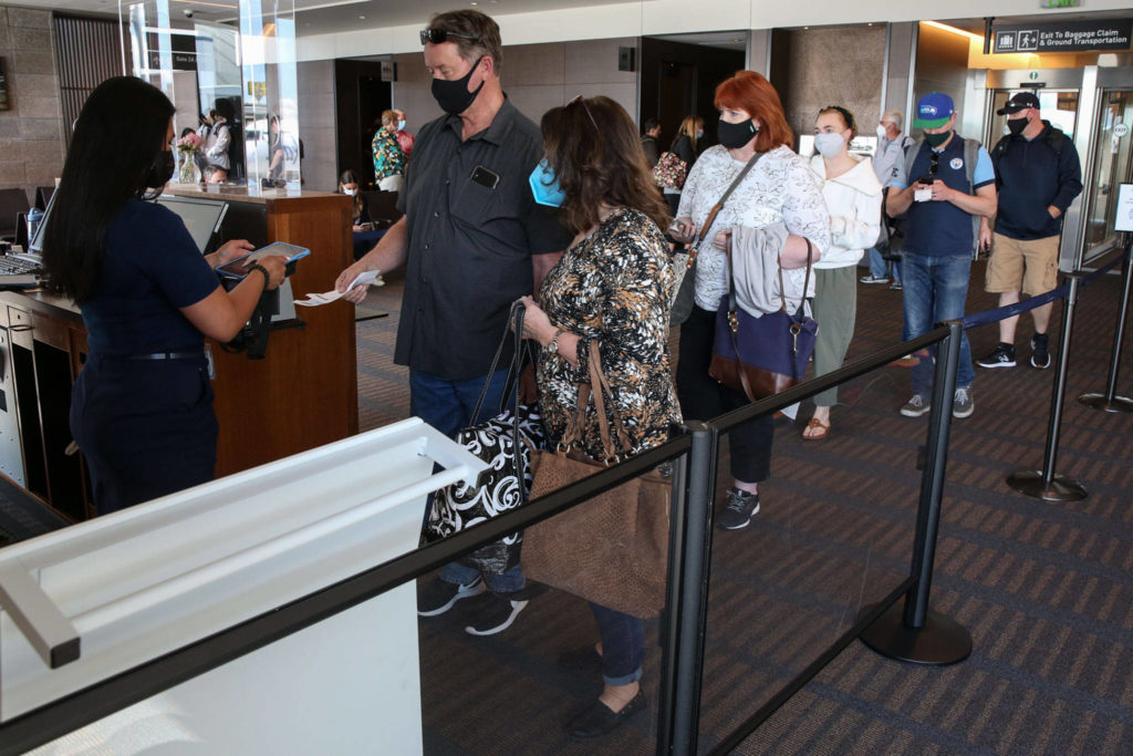 Passengers line up to board a flight to Las Vegas at Paine Field in Everett on May 19. (Kevin Clark / Herald file)
