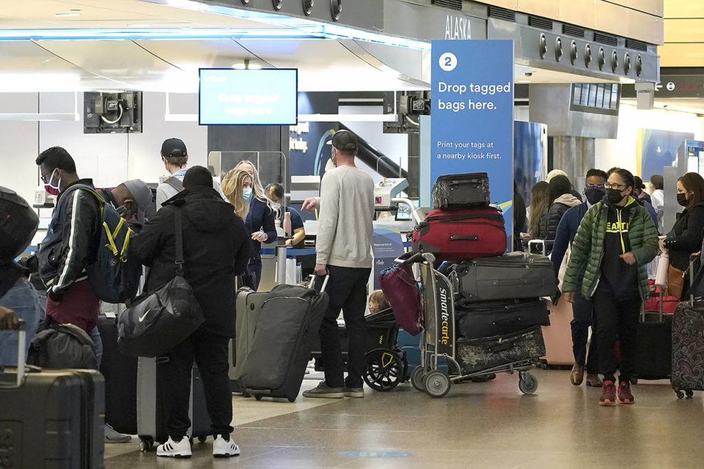 Passengers wait in line with luggage near an Alaska Airlines check-in area March 1 at Seattle-Tacoma International Airport in Seattle. (AP Photo/Ted S. Warren, file) 
