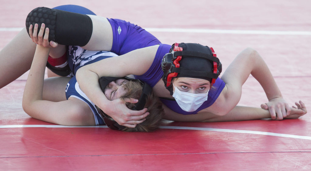 Lake Stevens’ Mikaela Miller (top) looks at the clock as she pins Glacier Peak’s Lillian Germer during a girls wrestling scramble held outside at Marysville Pilchuck High School on Tuesday in Marysville. (Andy Bronson / The Herald)
