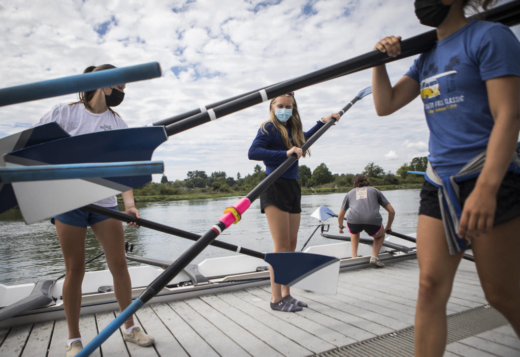 Taylor Fausey (left) and Mac Tuley grab their oars as they get into their boat. (Olivia Vanni / The Herald)
