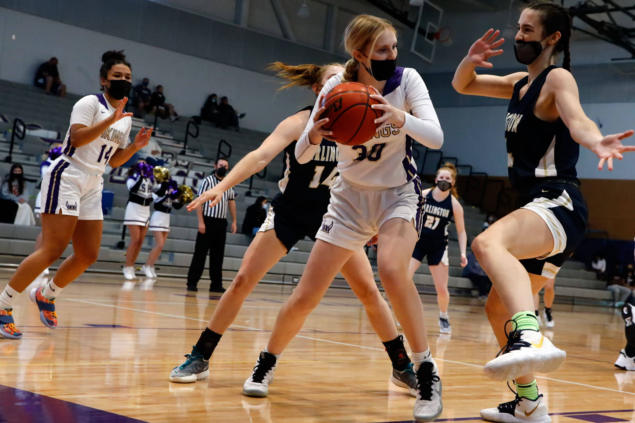 Lake Stevens’ Carmen Long (center) looks to pass out of Arlington’s defensive pressure during a game on Wednesday evening at Lake Stevens High School. Arlington won 80-71. (Kevin Clark / The Herald)