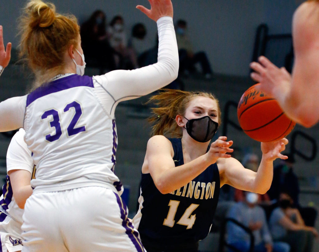 Arlington’s Keira Marsh (right) attempts a pass with Lake Stevens’ Cori Wilcox defending during a game on Wednesday evening at Lake Stevens High School. Arlington won 80-71. (Kevin Clark / The Herald)
