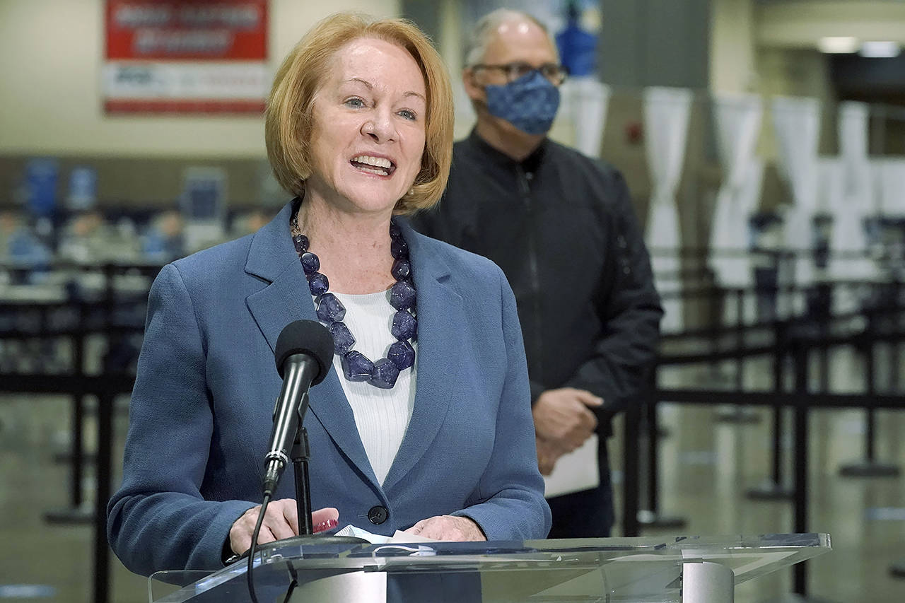 Seattle Mayor Jenny Durkan speaks at a news conference at Lumen Field Events Center in Seattle on March 10, with Gov. Jay Inslee looking on. The mayor announced Wednesday that Seattle has fully vaccinated 70% of its residents ages 12 and older. (AP Photo/Ted S. Warren, file)