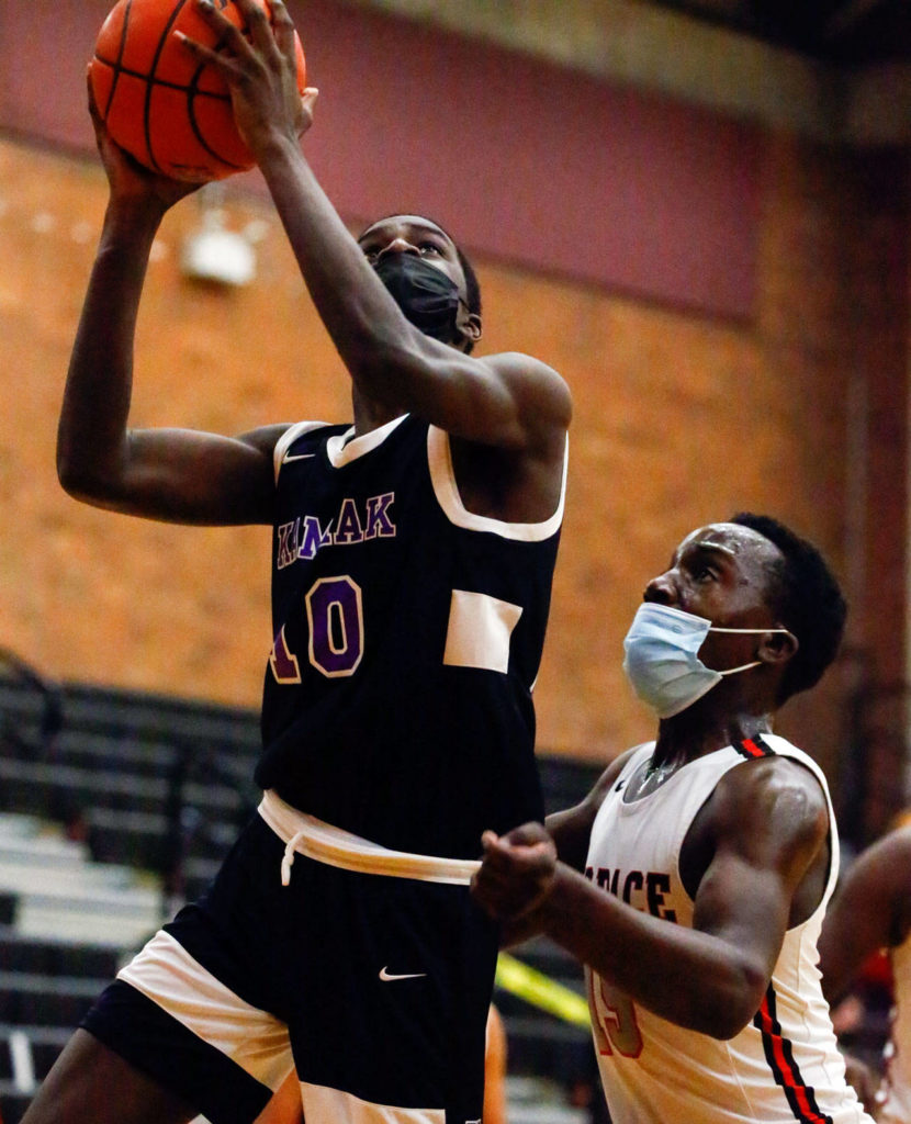Kamiak’s Josiah Pierre (left) attempts a shot with Mountlake Terrace’s Jeffrey Anyimah trailing during a game Thursday evening at Mountlake Terrace High School. The Hawks won 65-59. (Kevin Clark / The Herald)
