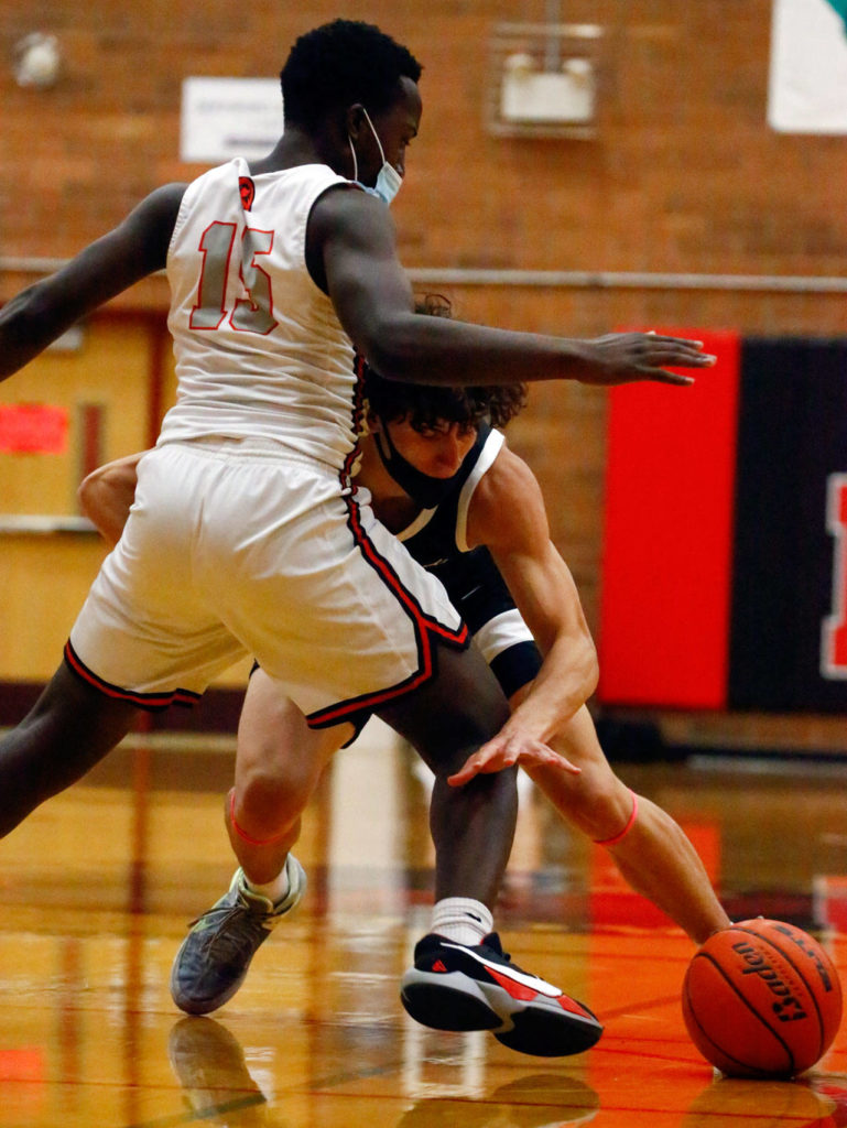 Kamiak’s Brendan Beier (right) looses the ball with Mountlake Terrace’s Jeffrey Anyimah defending during a game Thursday evening at Mountlake Terrace High School. The Hawks won 65-59. (Kevin Clark / The Herald)
