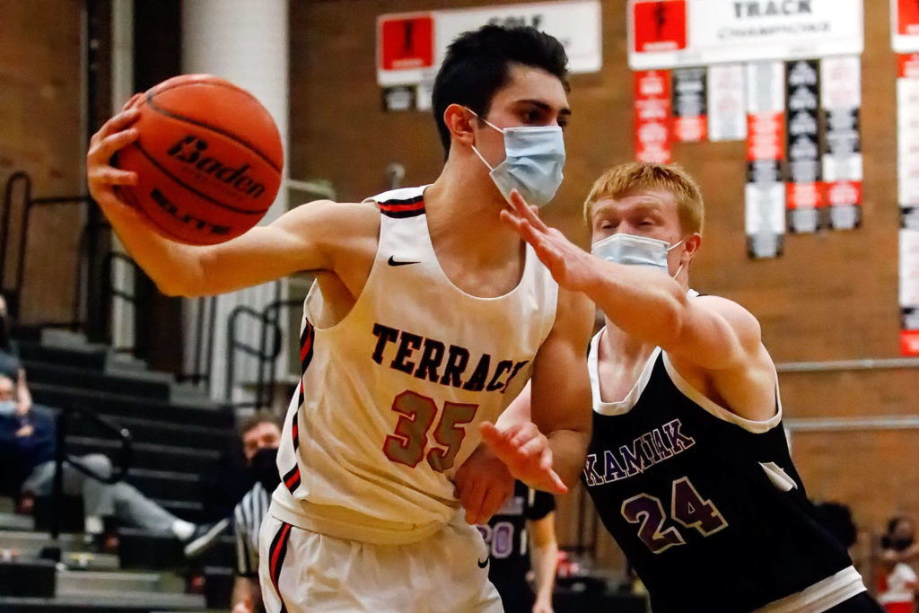 Mountlake Terrace’s Vitaly Mkrtychyan controls the ball with Kamiak’s Nolan Martin defending during a game Thursday evening at Mountlake Terrace High School. The Hawks won 65-59. (Kevin Clark / The Herald)
