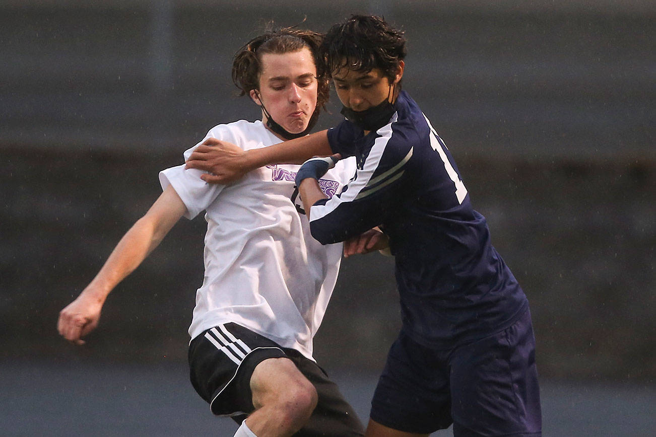 Lake Stevens' Jordan Ross and Arlington's Gio Castillo battle for the ball as Arlington beat Lakes Stevens 2-1 in a boys soccer march on Monday, May 3, 2021 in Arlington, Washington.  (Andy Bronson / The Herald)