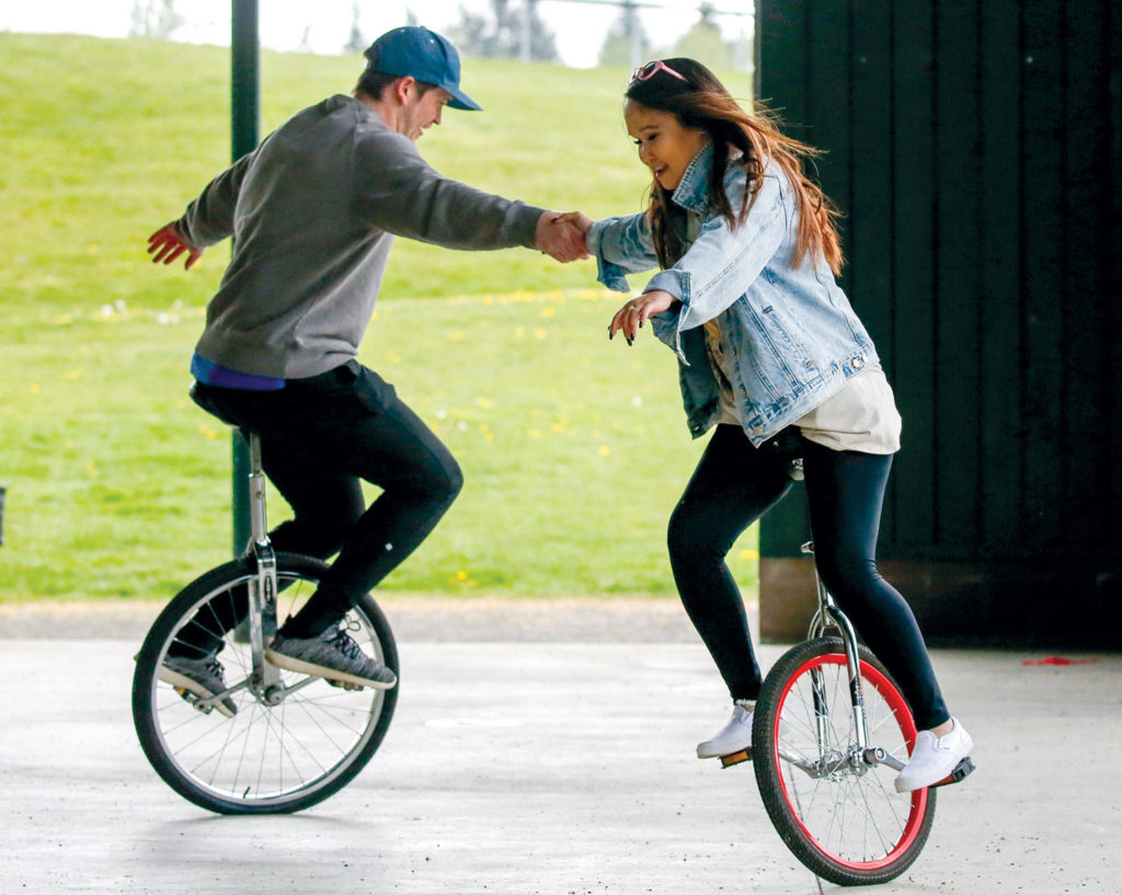 Nate Feltner and Rebecca Loran show off their unicycle skills at Willis Tucker Park. (Kevin Clark / The Herald)
