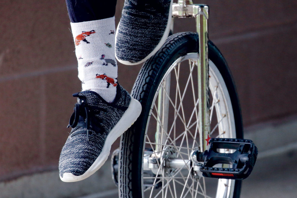 Patsy May does a wheel walk on her unicycle. (Kevin Clark / The Herald)
