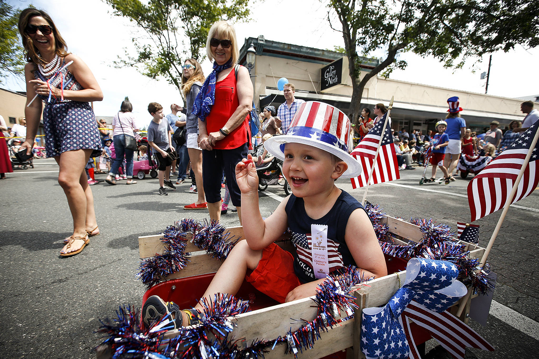 Jackson Emerick, 4, of Shoreline, tosses candy to crowds lining Main Street in downtown Edmonds during the Edmonds Kind of Fourth Parade on July 4, 2017. (Ian Terry / Herald file)