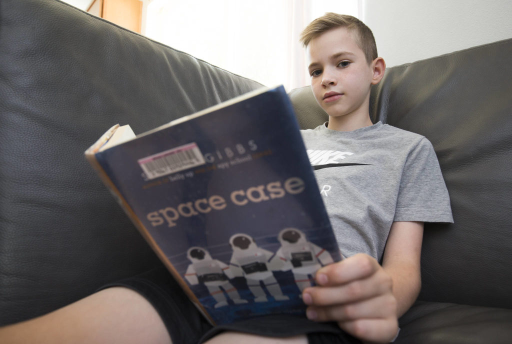 Willem Wolters is halfway through “Space Case” by Stuart Gibbs. The 9-year-old Bothell boy set a new national points record in the Accelerated Reader program. (Andy Bronson / The Herald)
