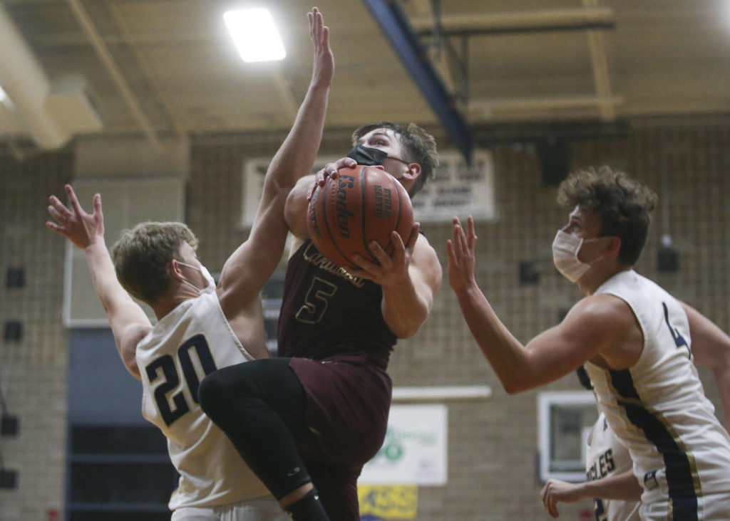 Lakewood’s Justice Taylor gets past Arlington defenders for a basket during a May 19 game in at Arlington High School. (Andy Bronson / The Herald)
