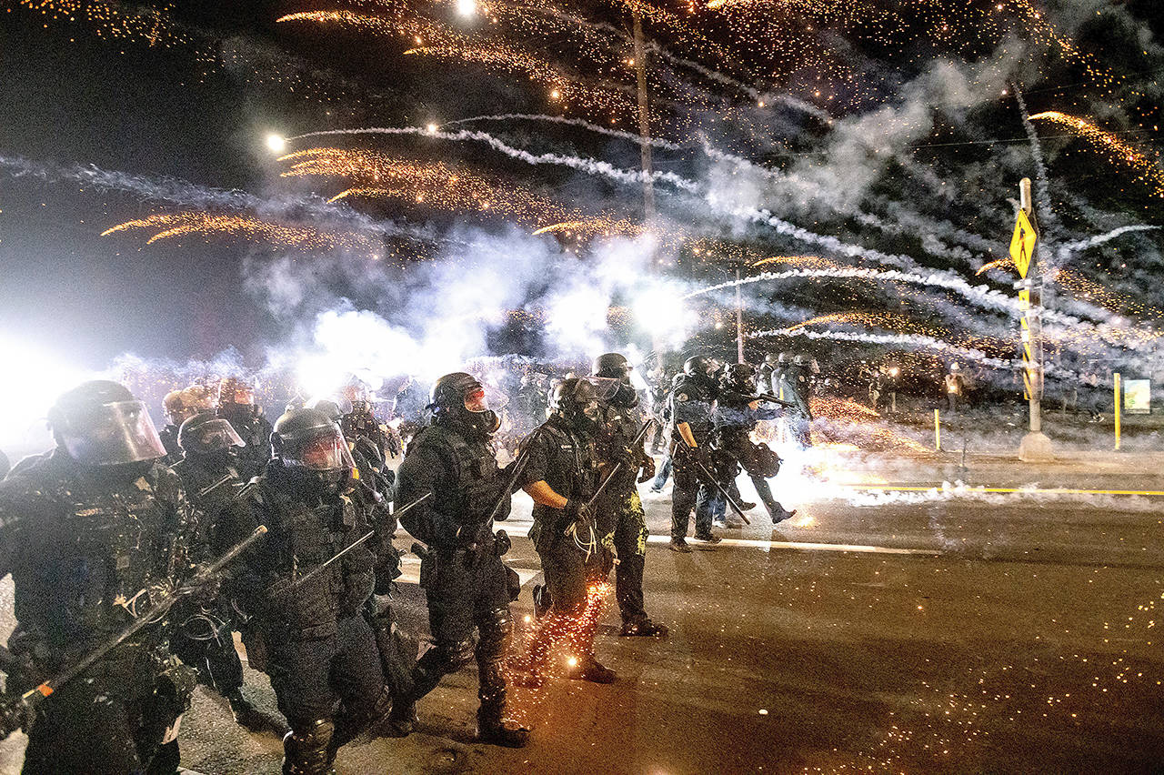 In this Sept. 5, 2020 photo, police use chemical irritants and crowd control munitions to disperse protesters during a demonstration in Portland. (AP Photo/Noah Berger, file)