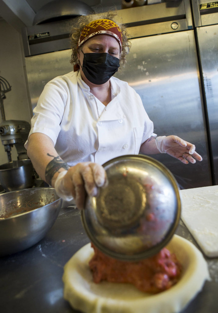 Village Taphouse and Grill head baker Cheryl Olsen fills a strawberry rhubarb pie. (Olivia Vanni / The Herald)
