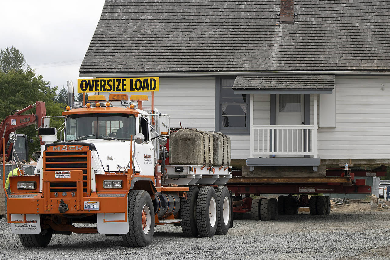 The historic Grimm House is towed to a new home to become part of the North Cove Park expansion in Lake Stevens. (Isabella Breda / The Herald)