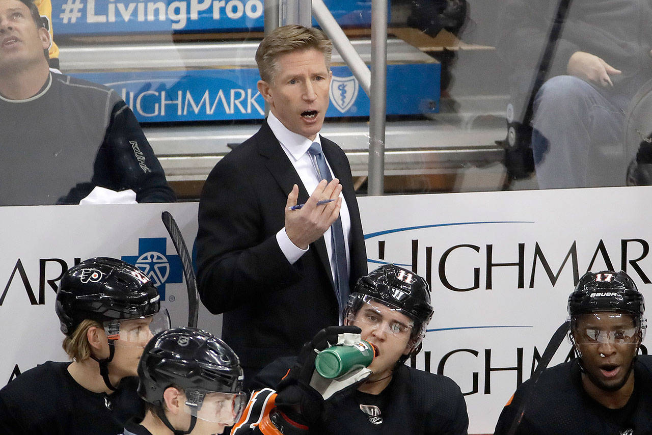 Philadelphia Flyers head coach Dave Hakstol gives instructions during a game while coaching the Philadelphia Flyers on Dec. 1, 2018. The Seattle Kraken hired Hakstol on Thursday as head coach of the expansion franchise that will begin its first NHL season in the fall. (AP Photo/Gene J. Puskar, File)