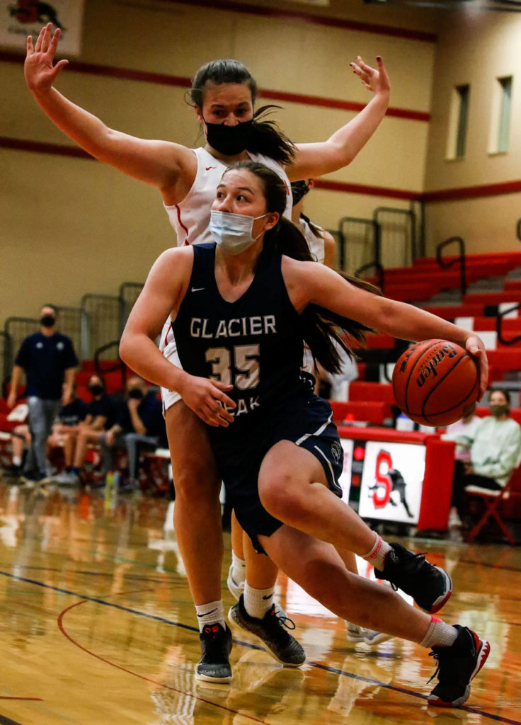 Glacier Peak’s Maya Erling drives to the basket with Snohomish’s Kyra Beckman defending during a game at Snohomish High School on May 28. (Kevin Clark / The Herald)
