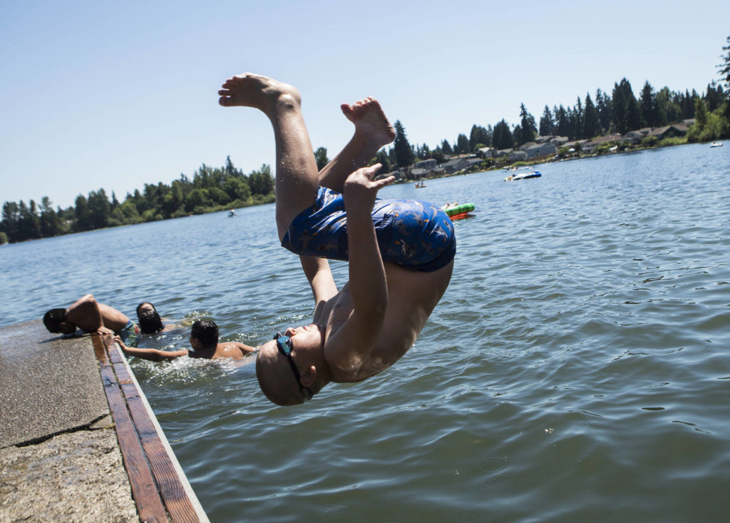 Malakai Iankov, 10, does a front flip off of a dock Saturday into Silver Lake at Thornton A. Sullivan Park in Everett. (Olivia Vanni / The Herald)
