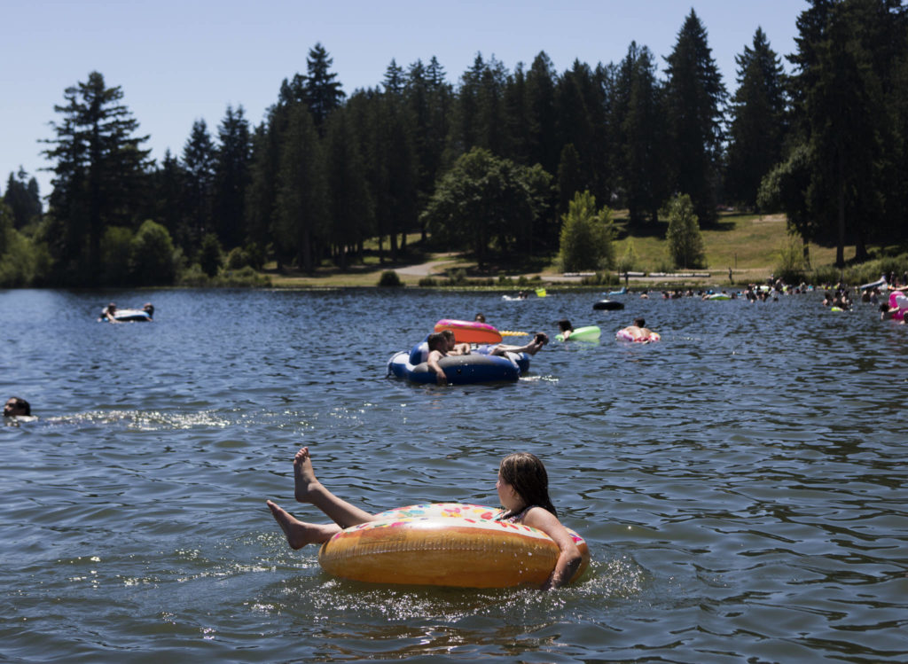 Ariana Blibd, 10, sits in a donut inner tube Saturday on Silver Lake at Thornton A. Sullivan Park in Everett. (Olivia Vanni / The Herald)
