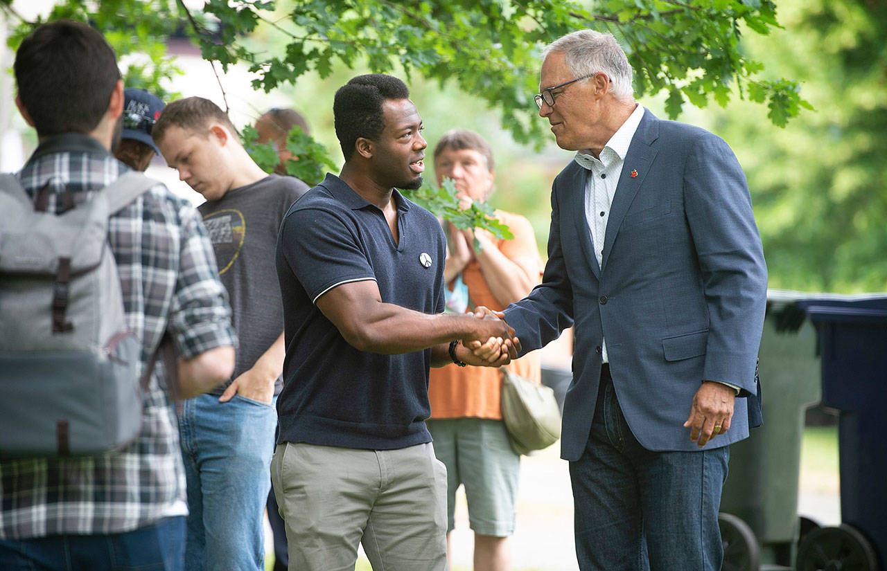Kwabi Amoah-Foreson of Tacoma greets Washington Gov. Jay Inslee at Wright Park in Tacoma during a celebration of the state’s reopening on Wednesday. (Tony Overman / The News Tribune via AP)