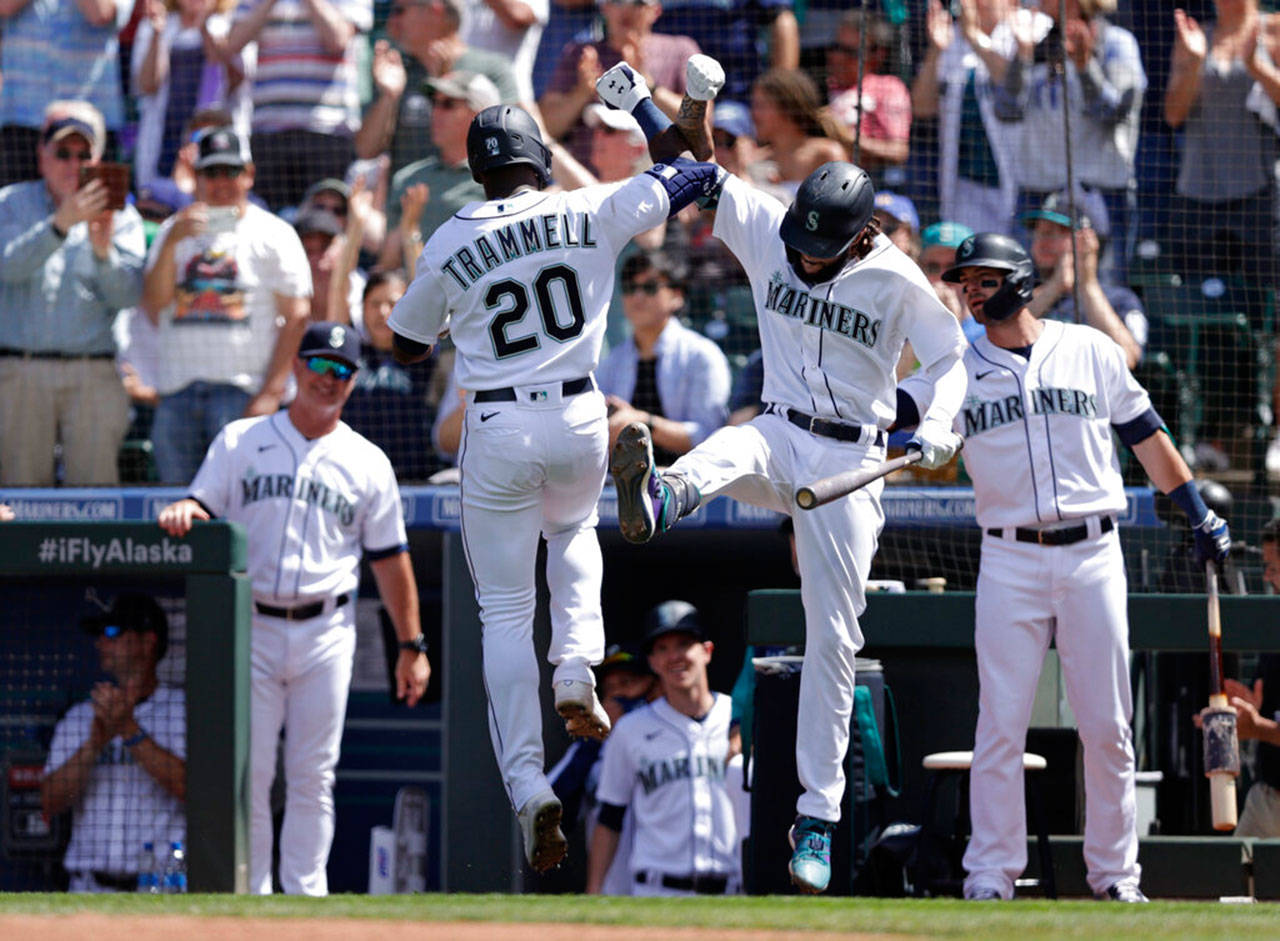 Seattle Mariner Taylor Trammell is greeted at home by J.P. Crawford after hitting a solo home run on a pitch from Colorado Rockies starting pitcher German Marquez during the sixth inning of the game, June 23, in Seattle. Another reason to celebrate: Washington state’s pandemic restrictions, such as capacity limits for most businesses and events, are set to be lifted on June 30. (John Froschauer / Associated Press)