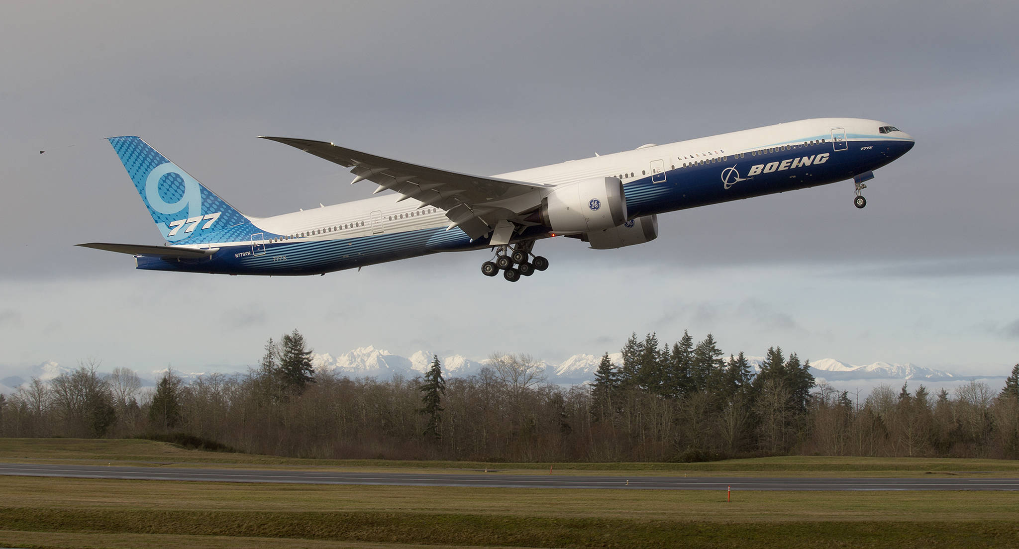 With the Olympic mountains in the background, Boeing’s 777x lifts off from Paine Field on its first flight, to Boeing Field in Seattle, on Jan. 25, 2020 in Everett. (Andy Bronson / Herald file)