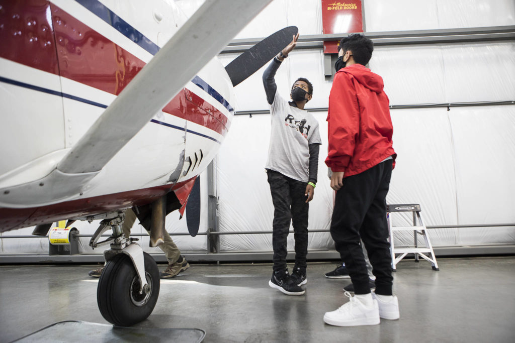 Djibril Garcia, 12, feels for divots or cracks along a propeller during a Red-Tailed Hawks Flying Club program at Arlington Municipal Airport. (Olivia Vanni / The Herald)
