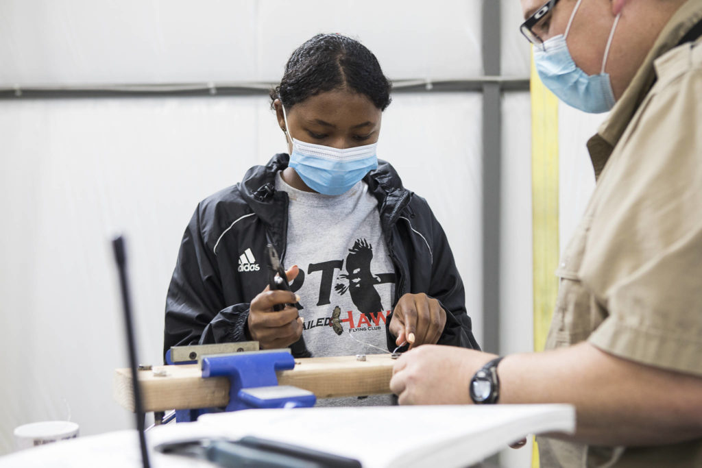 Erin Howard, 15, learns how to make a piece of safety wiring during a Red-Tailed Hawks Flying Club program at Arlington Municipal Airport. (Olivia Vanni / The Herald)
