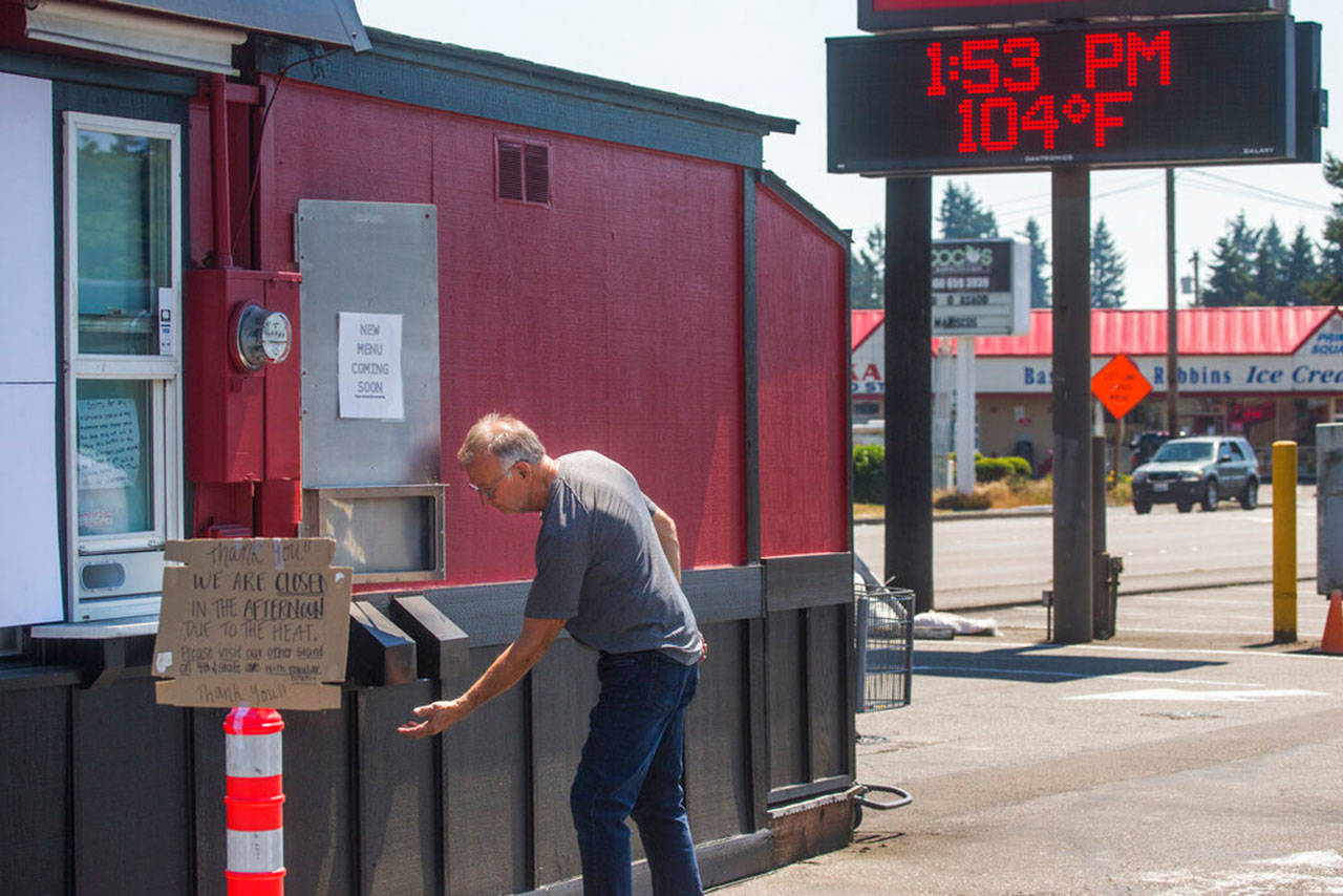 Jim Martin, owner of Espresso Connection, checks the heat flowing from a vent at one of his coffee stands, closed for the afternoon due to excessive heat, on Monday in Marysville. (Andy Bronson / The Herald)